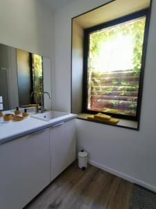 uma cozinha com um lavatório e uma janela em Gîte de charme au cœur de l'entre-deux-mers em Haux