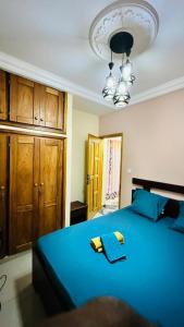 - une chambre avec un lit bleu et des placards en bois dans l'établissement Appartement haut standing ,Biyem Assi TKC, à Yaoundé