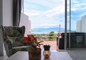 a living room with a chair and a table and a window at The Bay Condominium, 1-bed apartment with stunning sea views in Koh Samui