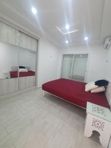 um quarto com uma cama vermelha num quarto branco em Villa de luxe avec piscine sans vis à vis Midoun em Aghīr