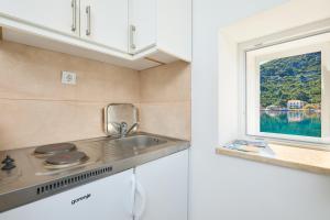 a kitchen with a sink and a window at Studio Sea Song in Maranovići