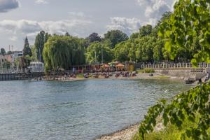 a body of water with people sitting on the shore at Casa Sofia in Friedrichshafen