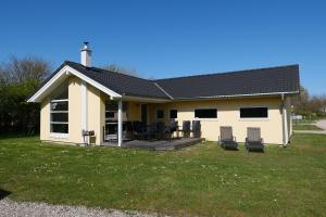 une maison avec des chaises et une terrasse dans la cour dans l'établissement Resort 1 Surfer's Residence E 137, à Großenbrode