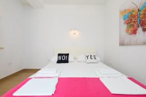 a room with a white bed with a pink rug at New studio Sea Song in Maranovići