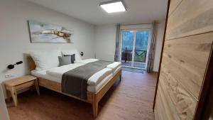 a bedroom with a bed and a large window at URLAUB LUNZ - Ferienwohnungen Fam. Fürst in Lunz am See