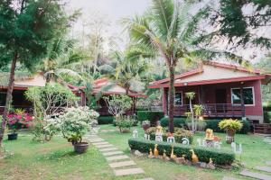a garden with chickens in front of a house at Siray Green Resort in Phuket