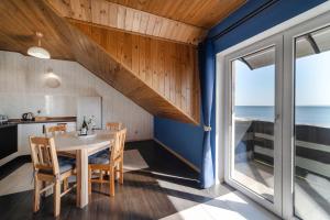 a dining room with a table and a view of the ocean at Pokoje Syberia Morska 20 in Kuźnica