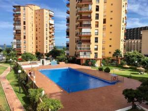 einen Pool in einem Apartmentkomplex mit hohen Gebäuden in der Unterkunft Apartamento entero Torremolinos beach in Torremolinos