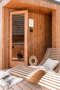 ビャウカにあるDomki w Białce WOODHOUSE- basen, sauna, jacuzziの木製サウナ(ドアの前にベッド付)