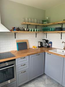 una cocina con armarios blancos y encimeras de madera en DEJA VU en Kretinga