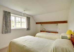 a bedroom with two beds and a window at Rosedale Abbey in Rosedale Abbey