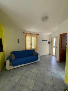 ein blaues Sofa im Wohnzimmer mit Fenster in der Unterkunft La Pavoncella (IUN R0521) in Lotzorai