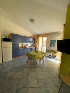 洛特佐拉伊的住宿－La Pavoncella (IUN R0521)，一间带桌椅的厨房和一间带蓝色橱柜的厨房