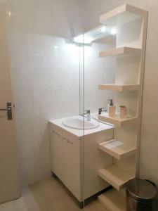 bagno bianco con lavandino e specchio di Destination Gers a Solomiac