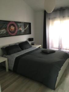 Un dormitorio con una cama grande y una ventana en Destination Gers, en Solomiac