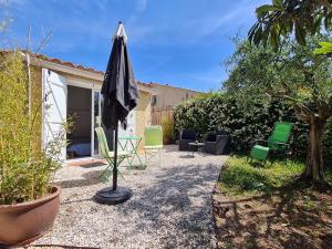 eine Terrasse mit Stühlen und einem Sonnenschirm im Hof in der Unterkunft Ti'colombier d Azur in Trans-en-Provence