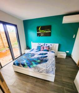 a bedroom with a bed and a green wall at Villa Pheron - De standing - Jacuzzi 5 Personnes in Baie-Mahault