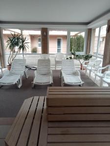 a group of white chairs and tables in a patio at Oázis Wellness Apartman2 in Hajdúszoboszló