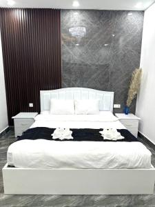 um quarto com uma grande cama branca com duas toalhas em The Morokot Paradise Homestay em Sihanoukville