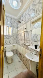 La salle de bains est pourvue de toilettes et d'un lavabo. dans l'établissement Appartement haut standing ,Biyem Assi TKC, à Yaoundé