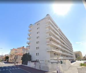 een wit gebouw met balkons aan de zijkant bij Appart proche plage avec grand balcon in Cannes
