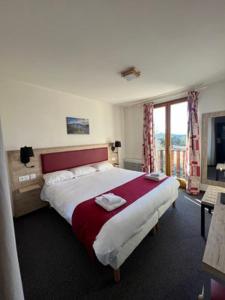 um quarto de hotel com uma cama grande e uma janela em Hôtel Espace Montclar em Montclar