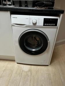 a washing machine in a kitchen with a counter at Garfield Cottage in Kettering