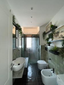 a bathroom with two sinks and a tub and a toilet at Verdemare, Casa & Panorama - Salerno, Amalfi Coast in Salerno