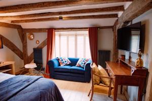 a bedroom with a blue couch in front of a window at The Print House Inn in Kent