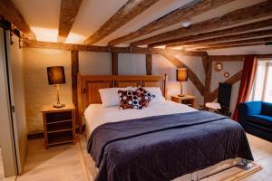 a bedroom with a large bed and a blue chair at The Print House Inn in Kent