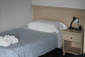ein Schlafzimmer mit einem Bett mit einer Lampe und einem Nachttisch in der Unterkunft Terme Villa Pace in Abano Terme