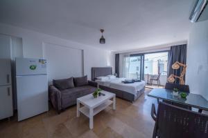 a living room with a couch and a bed and a table at İlya Apart 2 in Bodrum City