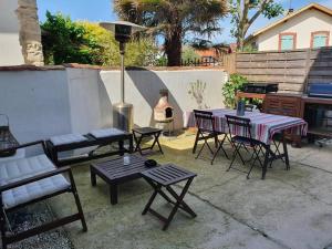 a patio with tables and chairs and a grill at Appartement sur cour privative in Capbreton +3 photos