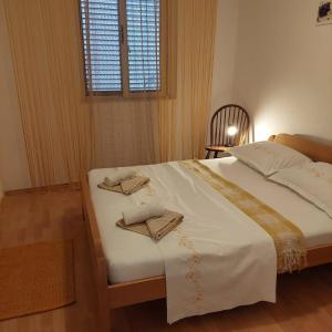 1 dormitorio con 1 cama con 2 toallas en Apartman Felicija, en Prigradica