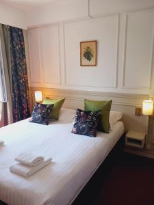 une chambre d'hôtel avec un lit et des serviettes. dans l'établissement Logis Le Relais Imperial, à Saint-Vallier-de-Thiey