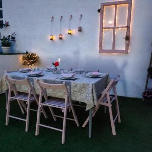 a dining room table with chairs and a table and a candle at Tu Casina del Norte in Luanco