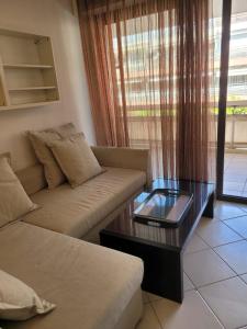 a living room with a couch and a coffee table at VILLENEUVE LOUBET PLAGE- Entre NICE et CANNES in Villeneuve-Loubet