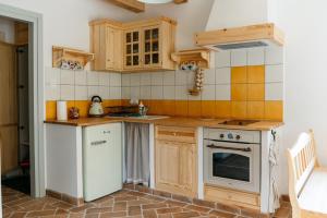 una cocina con electrodomésticos blancos y armarios de madera en Osada Biały Wilk domek "Żółty", en Przysłup