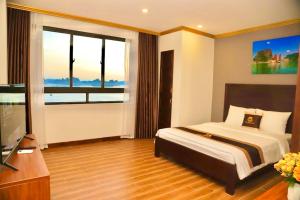 een slaapkamer met een bed en een groot raam bij Golden Sea HaLong Hotel in Ha Long