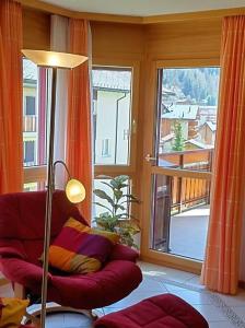 uma sala de estar com um sofá vermelho e uma grande janela em Château 26 em Leukerbad