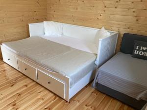 - une chambre avec un lit blanc et une chaise dans l'établissement Zarasaičio ežero sodyba, à Magučiai