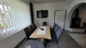 a dining room with a wooden table and chairs at Gyöngyike Apartmanház Vonyarcvashegy in Vonyarcvashegy