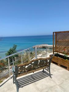 a bench sitting on a balcony overlooking the ocean at Sunside Inn Hotel in Kyrenia