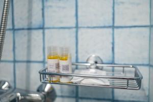 a rack with two bottles of moisturizers on a bathroom sink at Vintage Charm in Kos Town