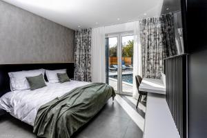 sypialnia z łóżkiem i biurkiem oraz balkon w obiekcie Villa Primus w mieście Gostinjac