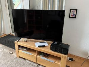 een grote flatscreen-tv op een houten standaard bij Nettes Appartment in Langenhagen in Hannover