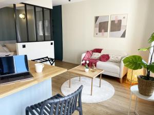 a living room with a laptop on a desk at escapade aux portes de Paris in Suresnes