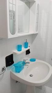 a white bathroom with a sink and a mirror at appartamento Walter in centro in Rosolina Mare
