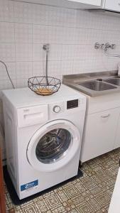 eine Waschmaschine und ein Waschbecken in der Küche in der Unterkunft appartamento Walter in centro in Rosolina Mare