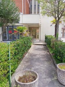 einen Gehweg vor einem Gebäude mit Pflanzen in der Unterkunft appartamento Walter in centro in Rosolina Mare